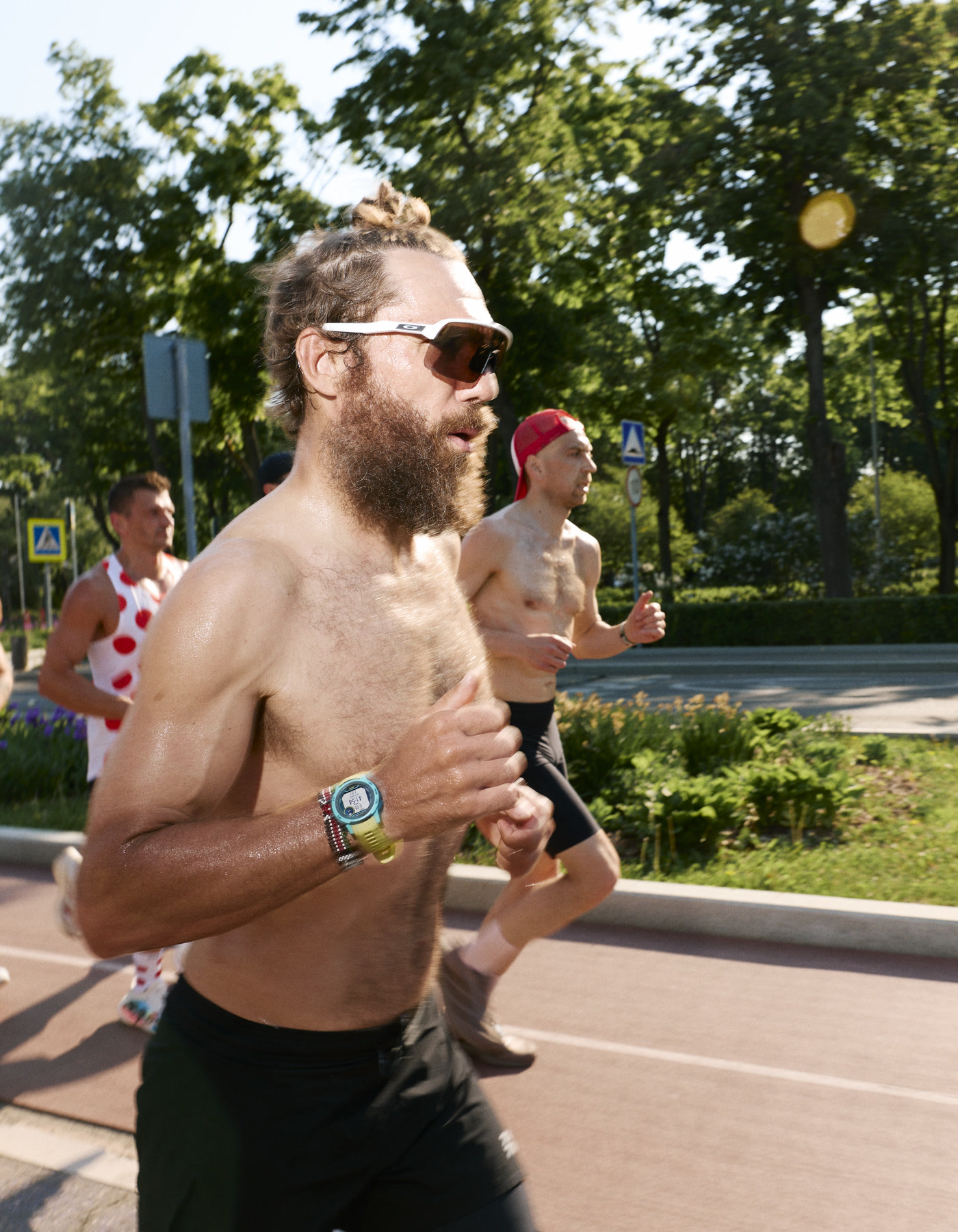Viktor Doronin runs with a group along a sunlit track